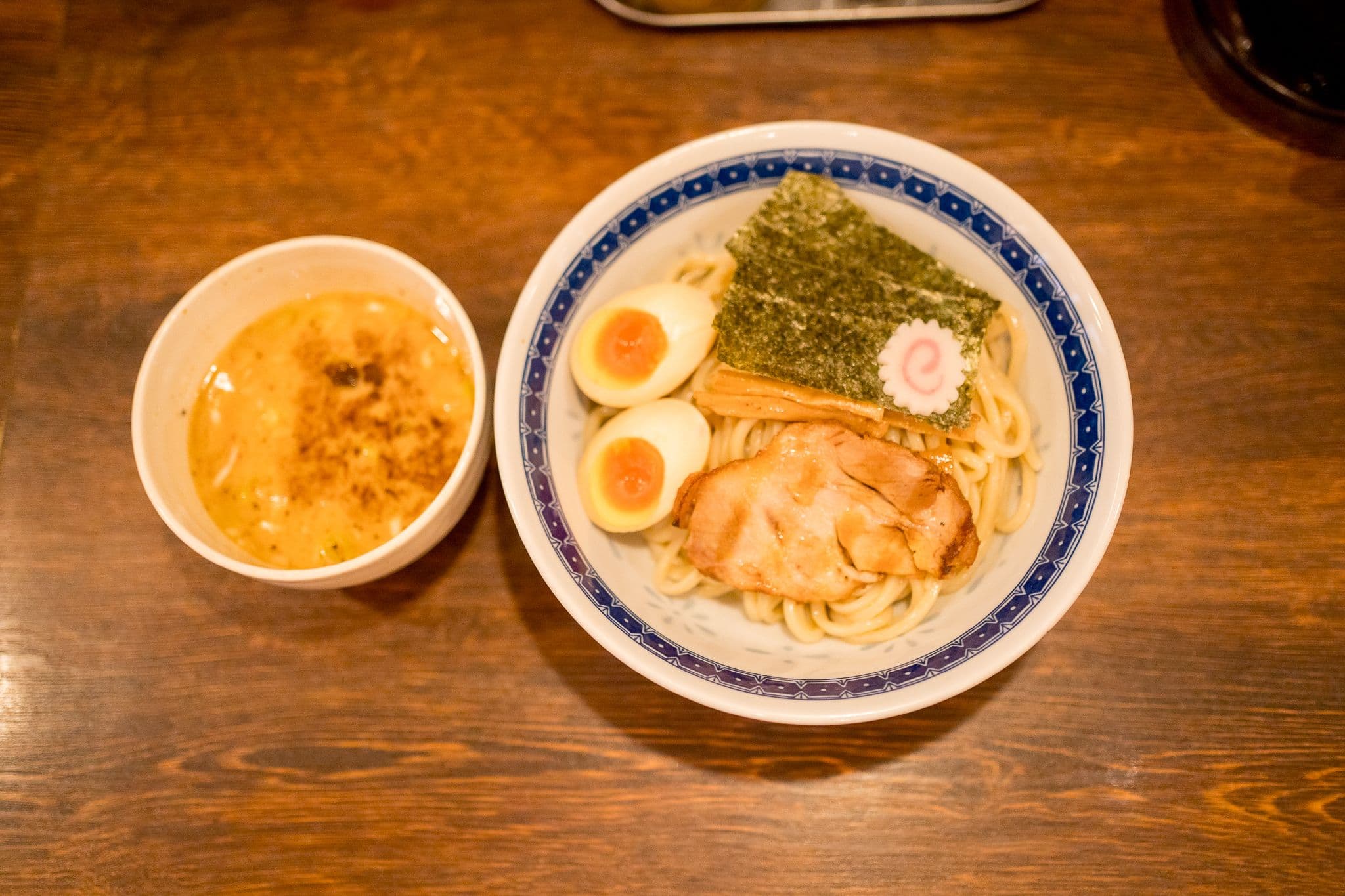 A large bowl of Tsukemen with pork cutlet, egg, and nori seaweed
